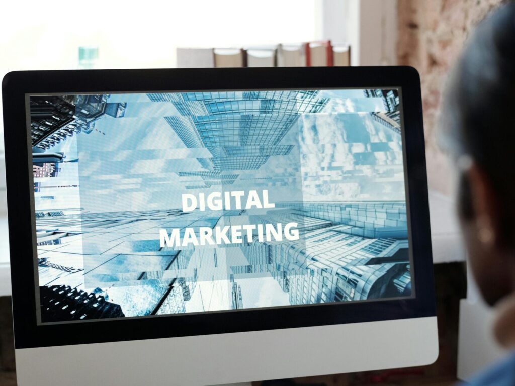 An individual focused on digital marketing on a desktop computer in a cozy workspace.